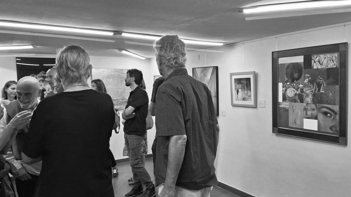 Visitantes ante las obras colgadas en una sala de exposición.