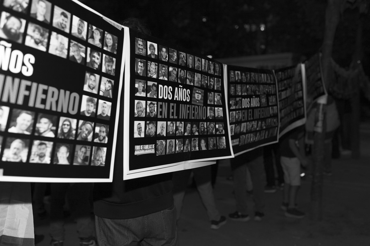 Pancarta con fotografías de personas secuestradas desplegada en una concentración.